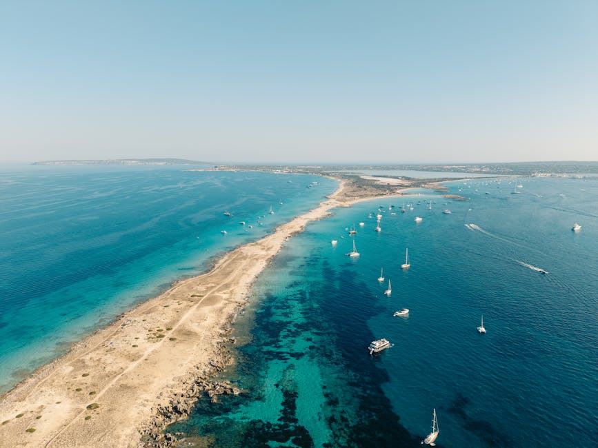 Aerial view of Formentera coastline with sailing boats on turquoise water