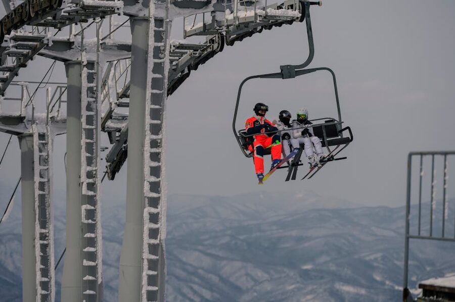 Skiers on chairlift above a snowy mountain valley in Korea