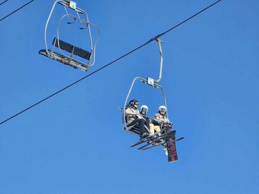 Three skiers riding a chairlift under clear blue sky at a Korean ski resort