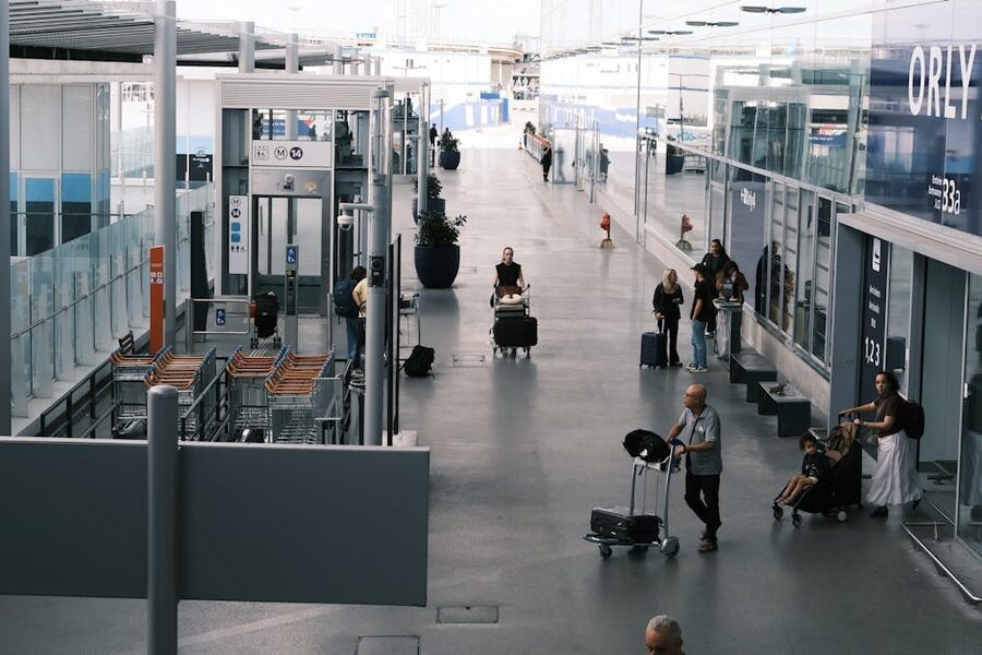 Travellers pulling suitcases through an airport arrivals corridor