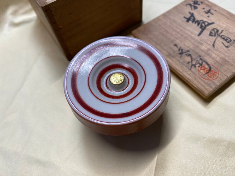 A handcrafted Japanese ceramic bowl featuring a red spiral design