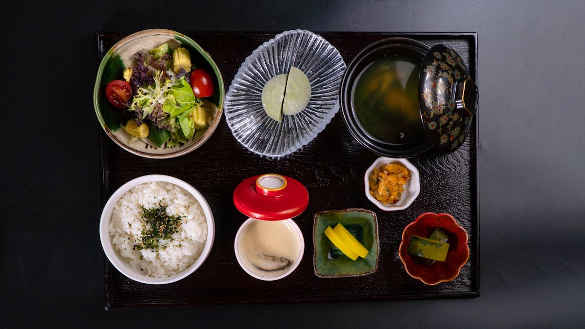 Top view of a traditional Japanese meal with rice soup salad and side dishes