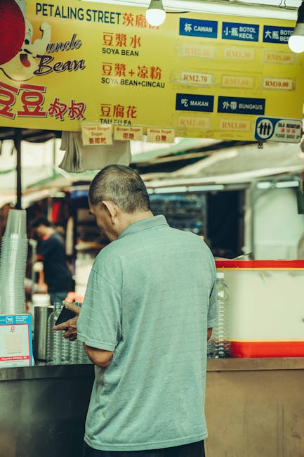 Customer buying food at a street stall in Petaling Street Kuala Lumpur