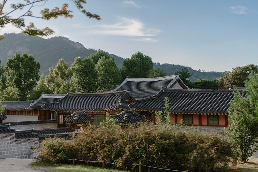 Traditional Korean hanok houses surrounded by countryside greenery