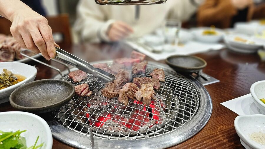 Korean barbecue with grilled meat and kimchi side dishes