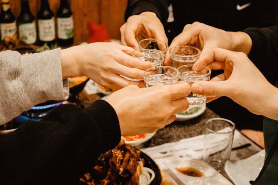 Clinking soju shot glasses at a tasting
