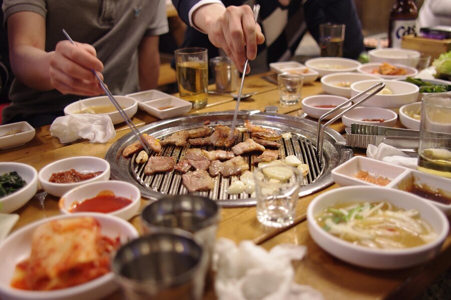 Korean pork belly meal with soju bottles on the table
