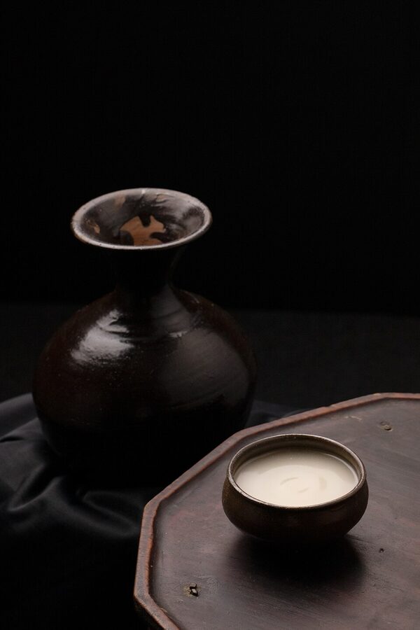 Traditional makgeolli bowl with Korean snacks