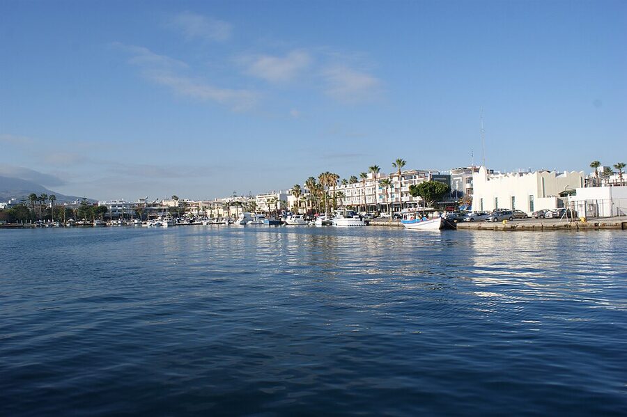 Kos Town harbour with traditional boats and waterfront tavernas at evening