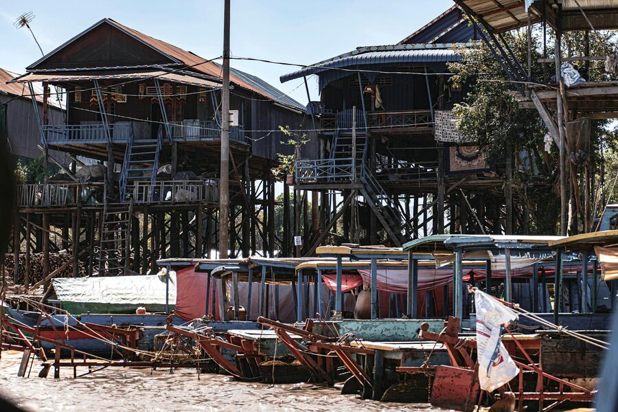 Rustic stilt houses and small boats in Kampong Phluk