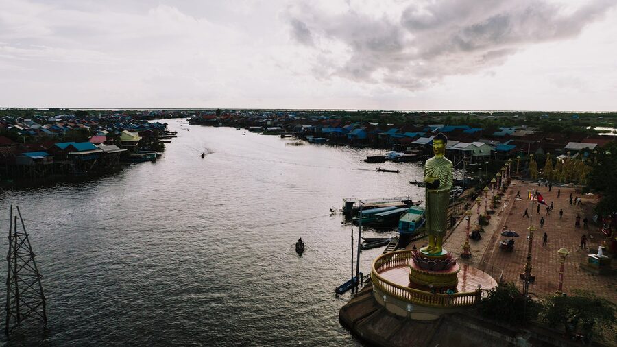 Aerial view with Buddha statue by the river in a Cambodian village