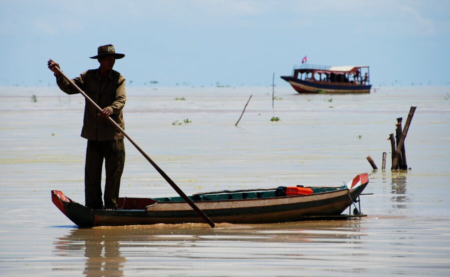 Cambodian fisherman standing on a small boat