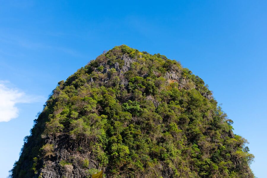 Limestone cliff formation rising above jungle canopy in Krabi Thailand