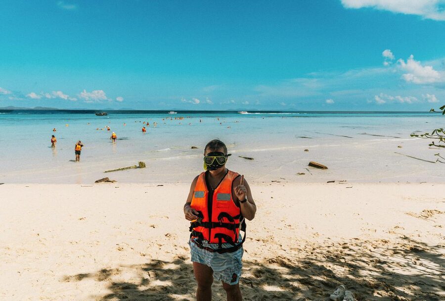 Person with snorkeling gear on a sunny beach in Thailand