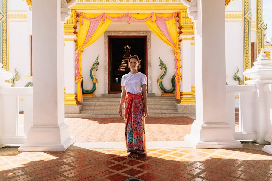 Woman standing at a colorful Thai temple entrance in Krabi