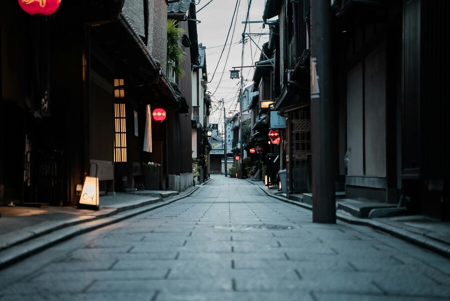 Narrow Kyoto alley lined with red lanterns creating a warm atmospheric glow