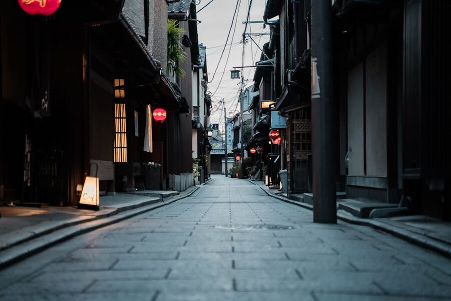 Kyoto alleyway with red lanterns and wooden houses