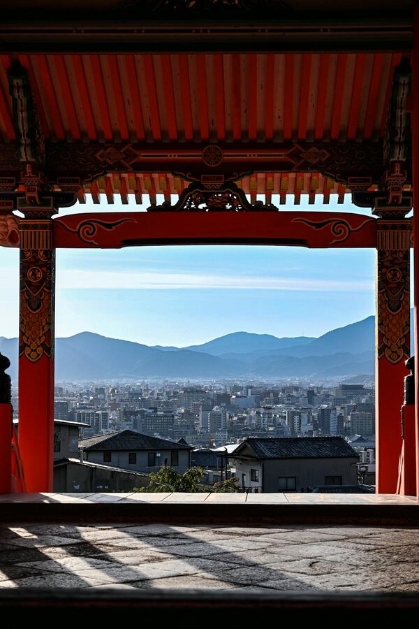View of Kyoto cityscape through a traditional Japanese temple archway