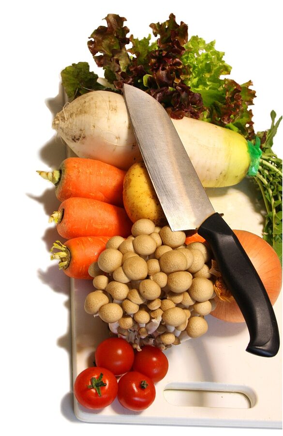 Chopping vegetables on a wooden board during prep