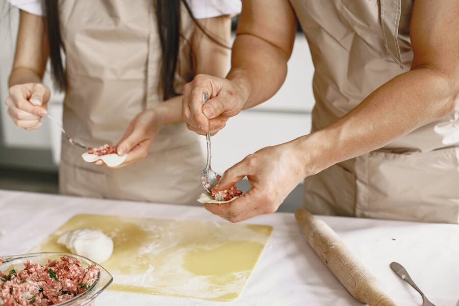 Two people making homemade gyoza dumplings from scratch