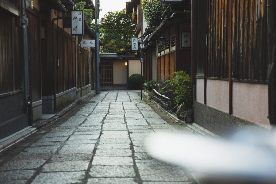 Atmospheric pedestrian alley with traditional Japanese houses and stone walls in Kyoto