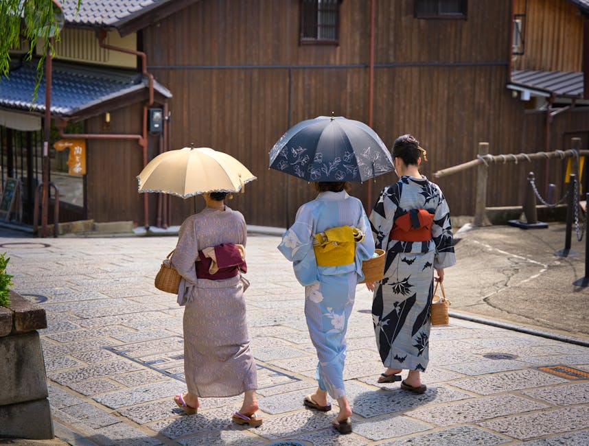 Three women in kimono with umbrellas in Kyoto