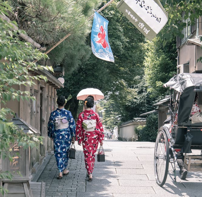 Two women in kimono under a parasol in Kyoto
