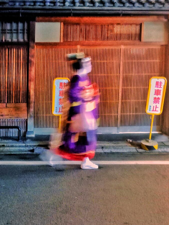 Maiko walking to appointment in evening Kyoto