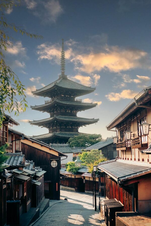 Traditional pagoda and old wooden buildings in Kyoto lit by sunset light