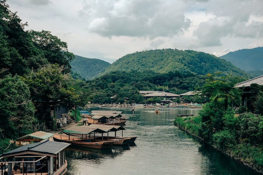 Arashiyama riverside with wooden boats and mountains