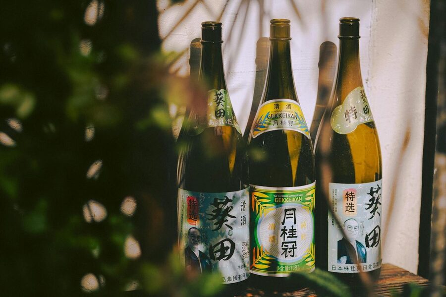 Three traditional Japanese sake bottles with distinctive labels
