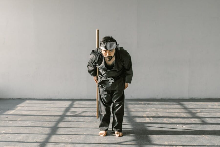 Martial artist bowing with wooden sword in a dojo