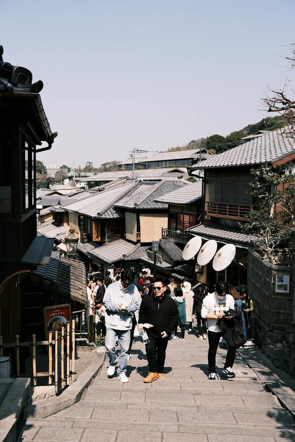 Crowded traditional street in Kyoto with travelers exploring historic shops