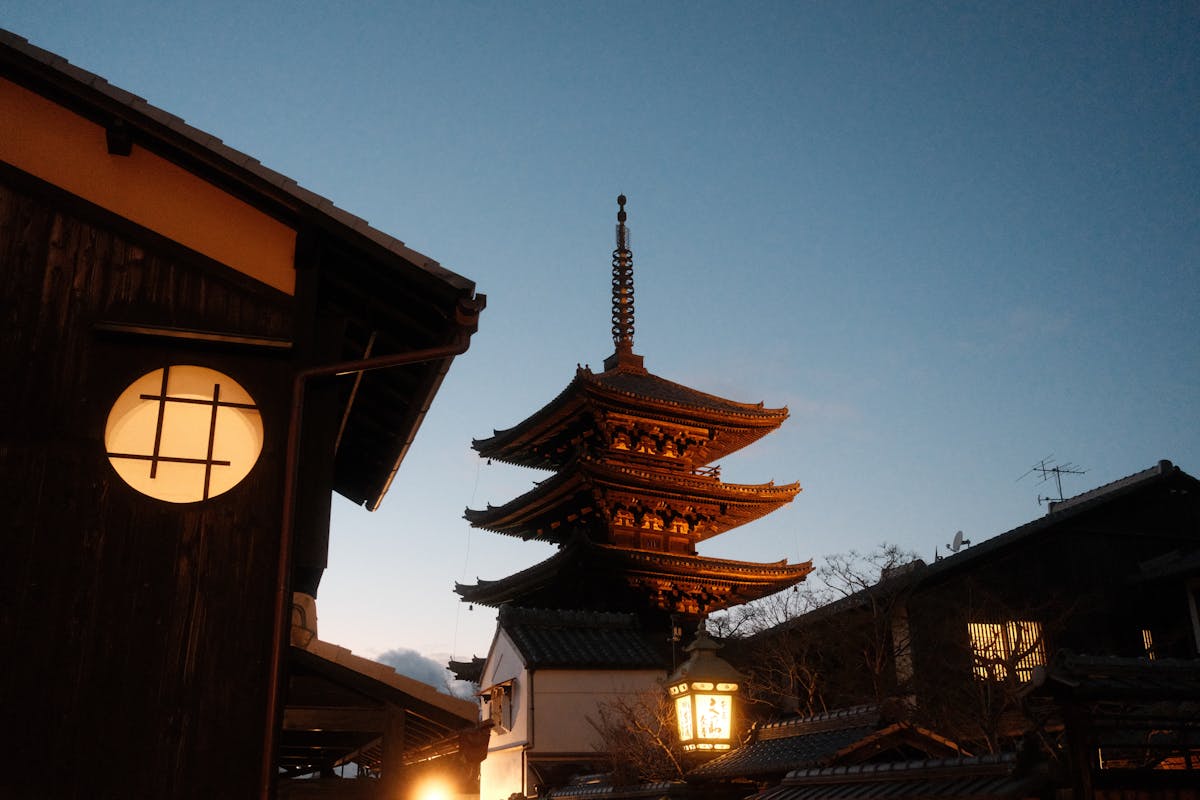 Illuminated pagoda against evening sky in Kyoto