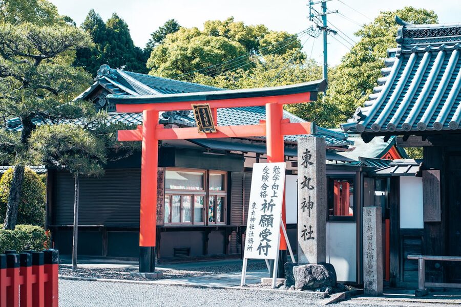 Red torii gate entrance to a shrine in Kyoto surrounded by greenery