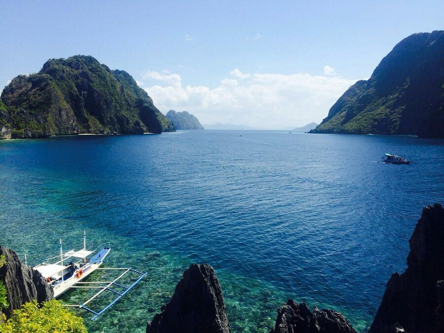Crystal clear tropical lagoon with boats and cliffs