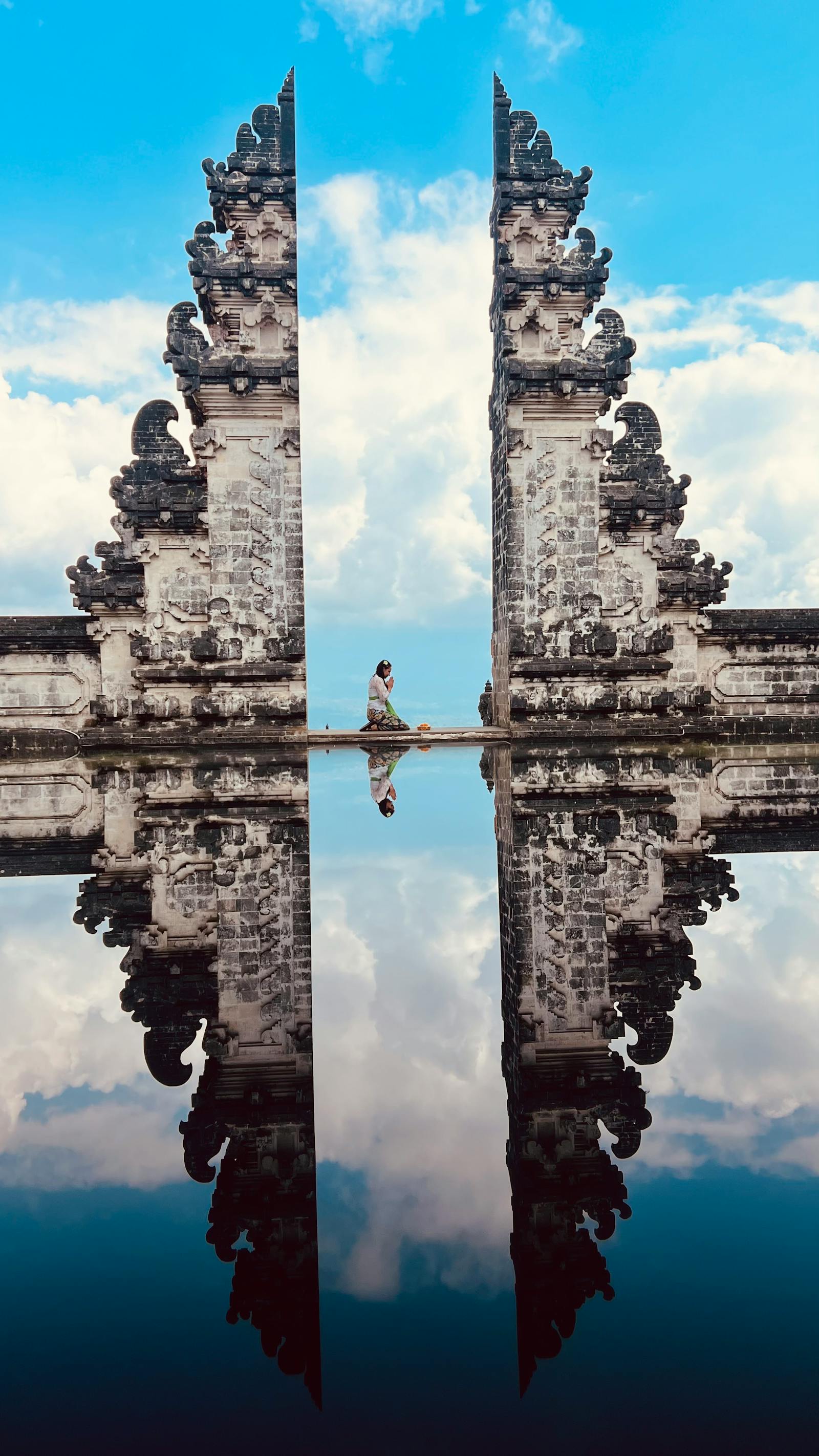 Symmetrical reflection of Pura Lempuyang's split gate under a blue sky