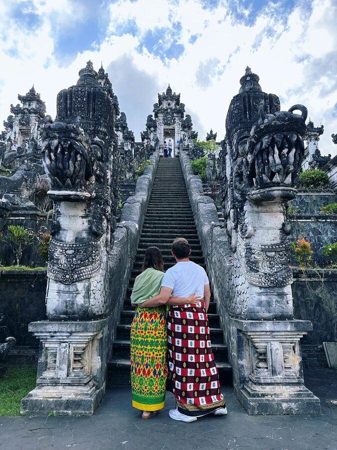 Couple in traditional attire admiring the grand staircase at Lempuyang Temple