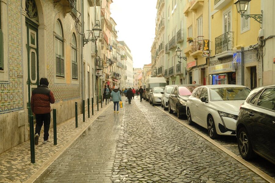 People walking on Alfama cobblestone street Lisbon
