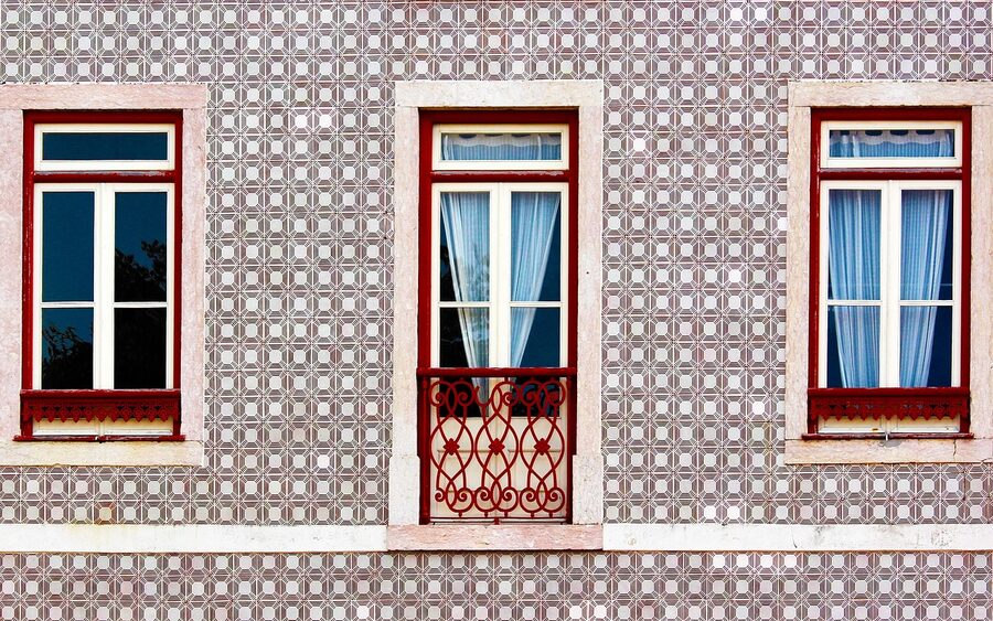 Old Alfama window with azulejo tiles around frame