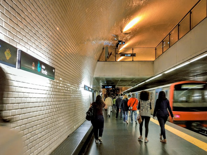 Commuters walking along Lisbon metro platform with moving train