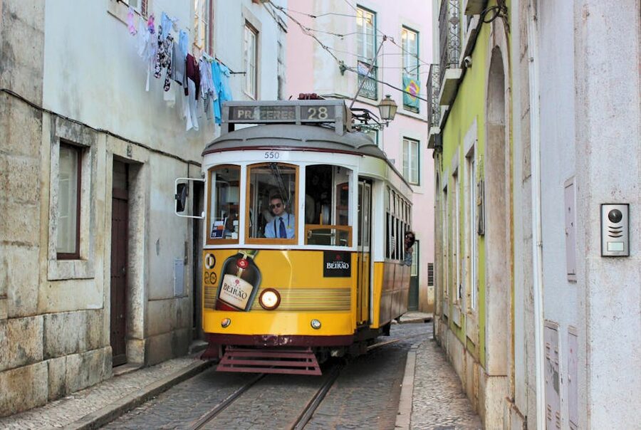 Yellow Lisbon tram 28 in narrow Alfama street