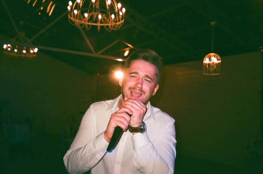 Male singer performing under warm hanging lights