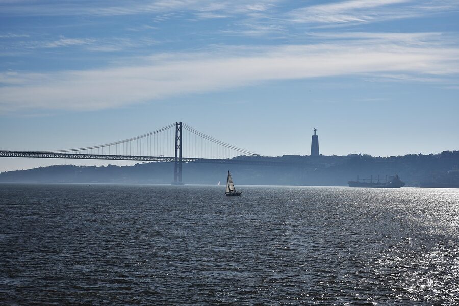 Small sailing boat on the Tagus near 25 de Abril Bridge, Lisbon