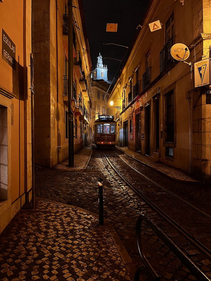 Lisbon Tram 28 in the evening on a narrow street