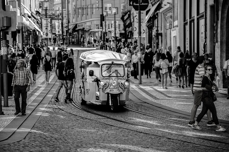 Lisbon tuk-tuk on tram line in shopping district street
