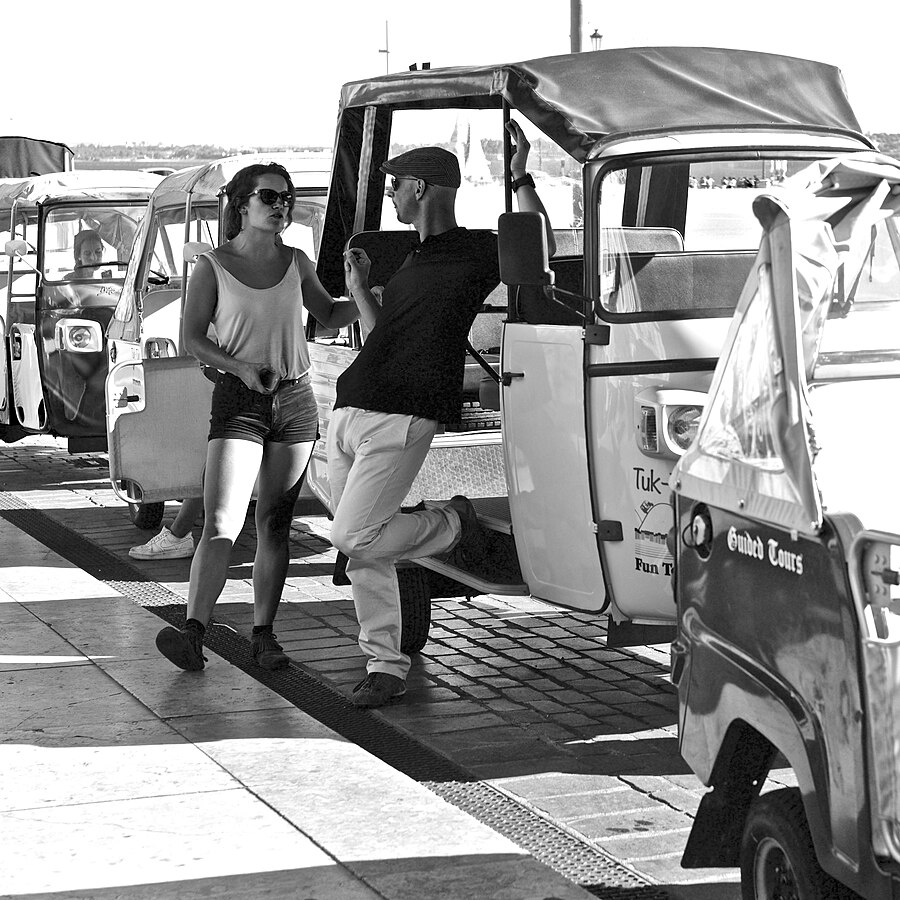 Tuk tuks paused at Terreiro do Paco Lisbon waiting for passengers