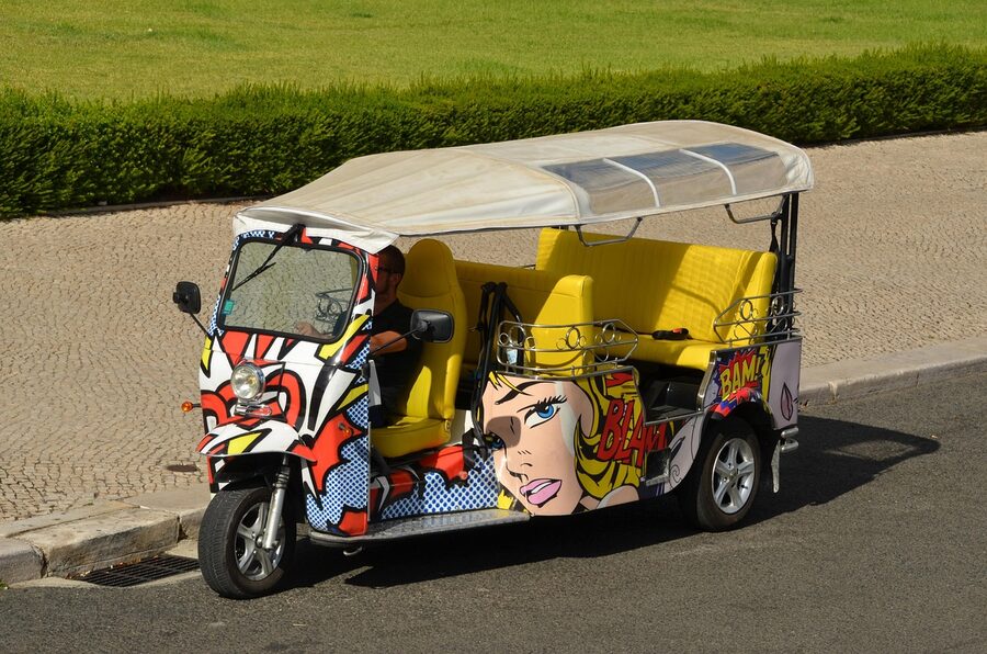 Lisbon tuk-tuk side view showing tricycle and seating