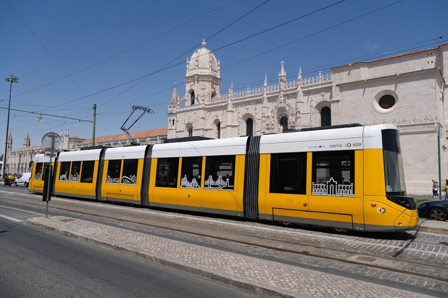 Yellow tram passing the Jerónimos Monastery in Lisbon