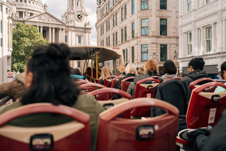 Tourists riding a London open-top bus past city landmarks
